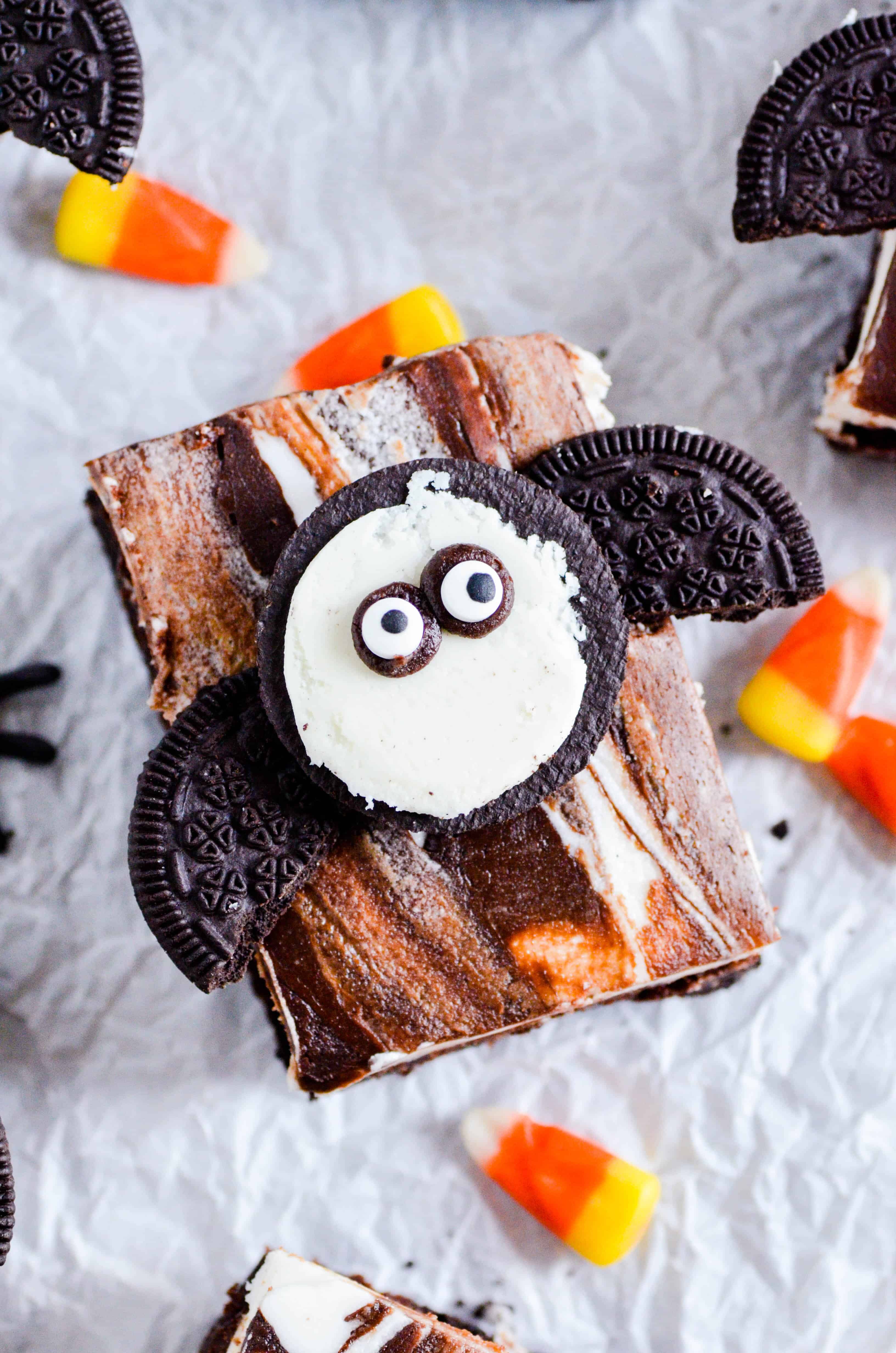 Fudgy brownies with a layer of Oreos in the middle topped with a whipped vanilla buttercream, fudge sauce, and another Oreo for good measure.