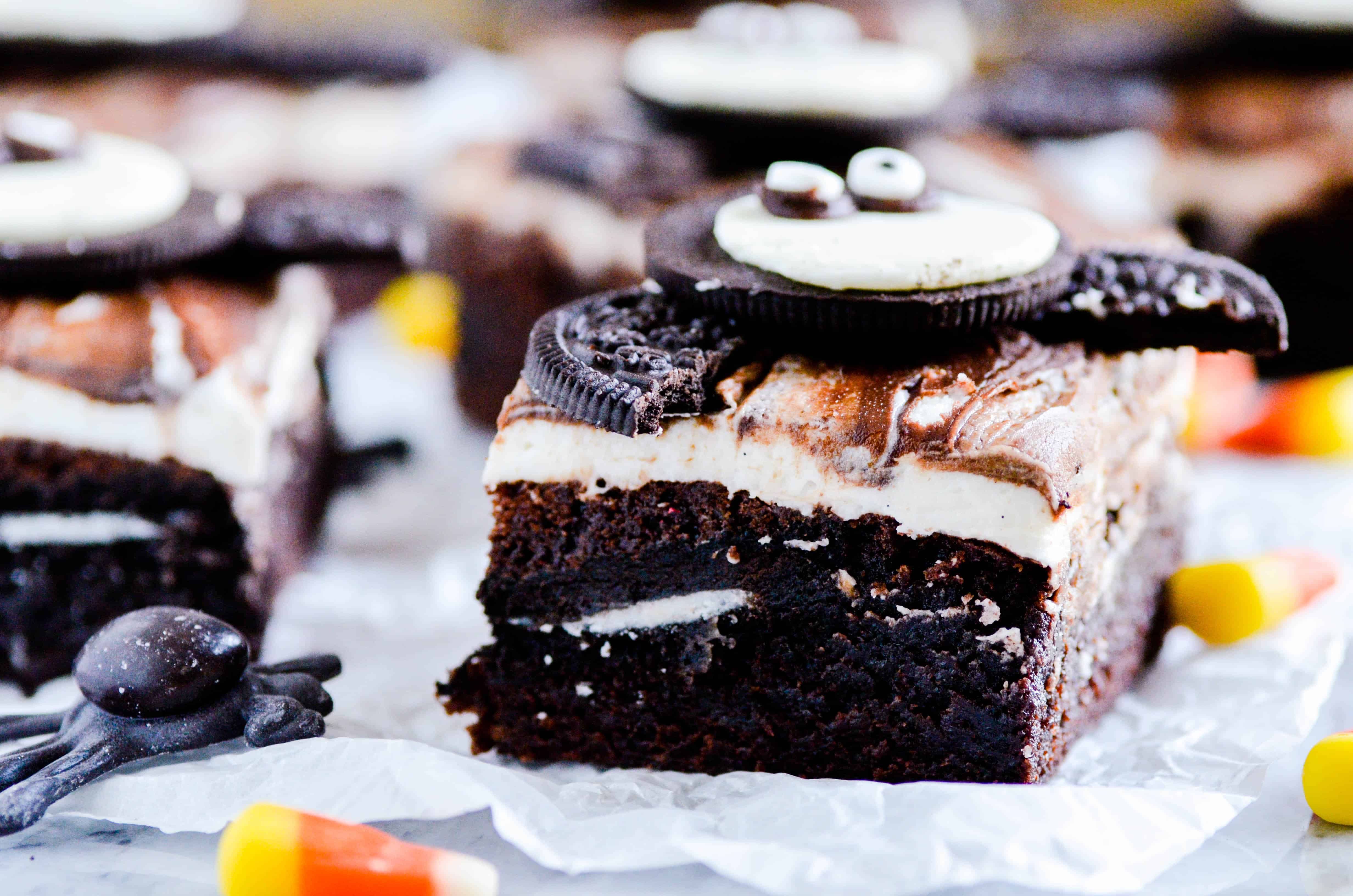 Fudgy brownies with a layer of Oreos in the middle topped with a whipped vanilla buttercream, fudge sauce, and another Oreo for good measure.