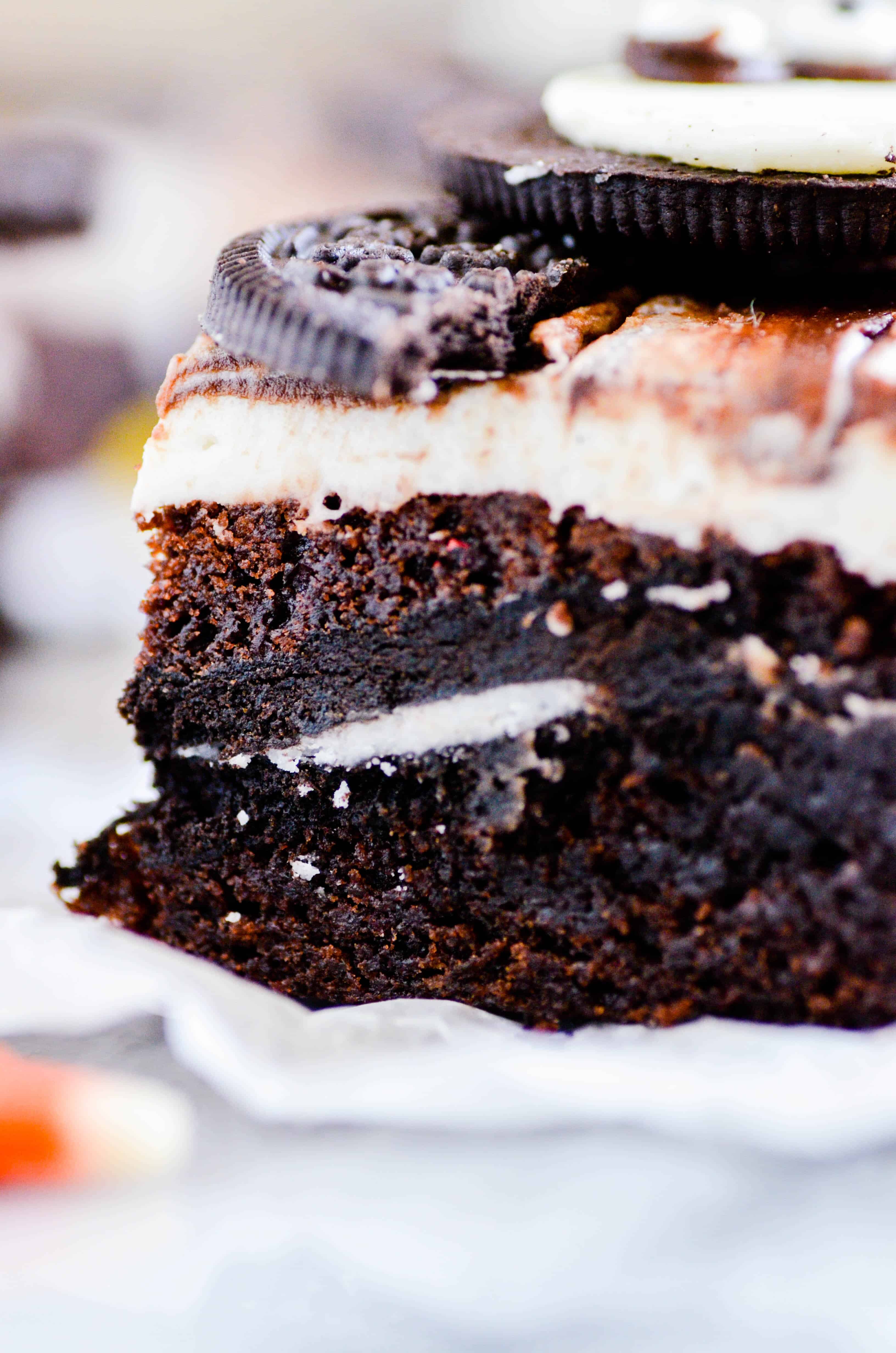 Fudgy brownies with a layer of Oreos in the middle topped with a whipped vanilla buttercream, fudge sauce, and another Oreo for good measure.