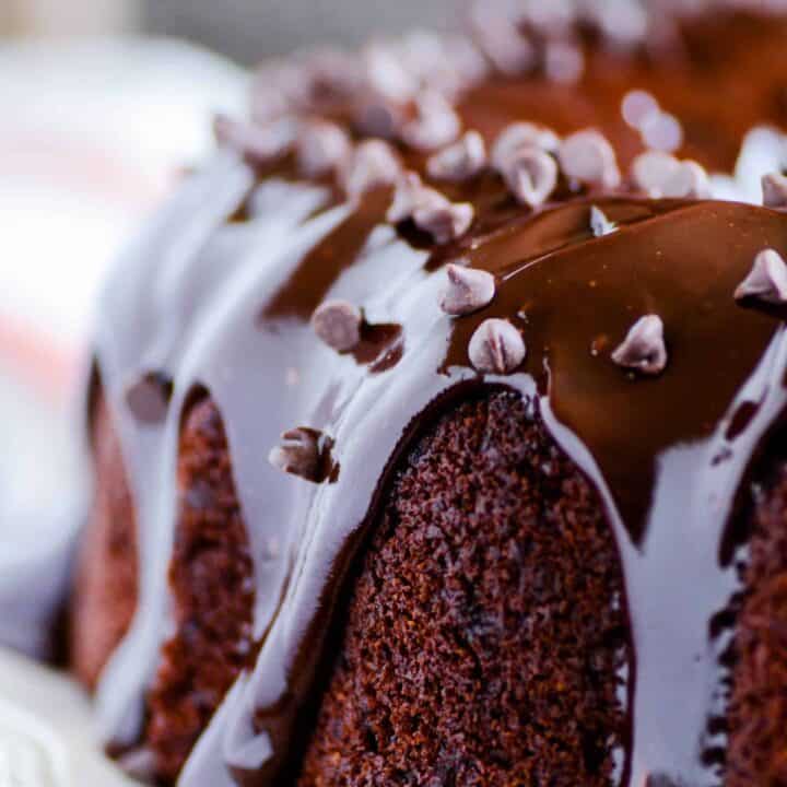 Rich and moist chocolate zucchini cake with chocolate chips and a decadent chocolate ganache on top!