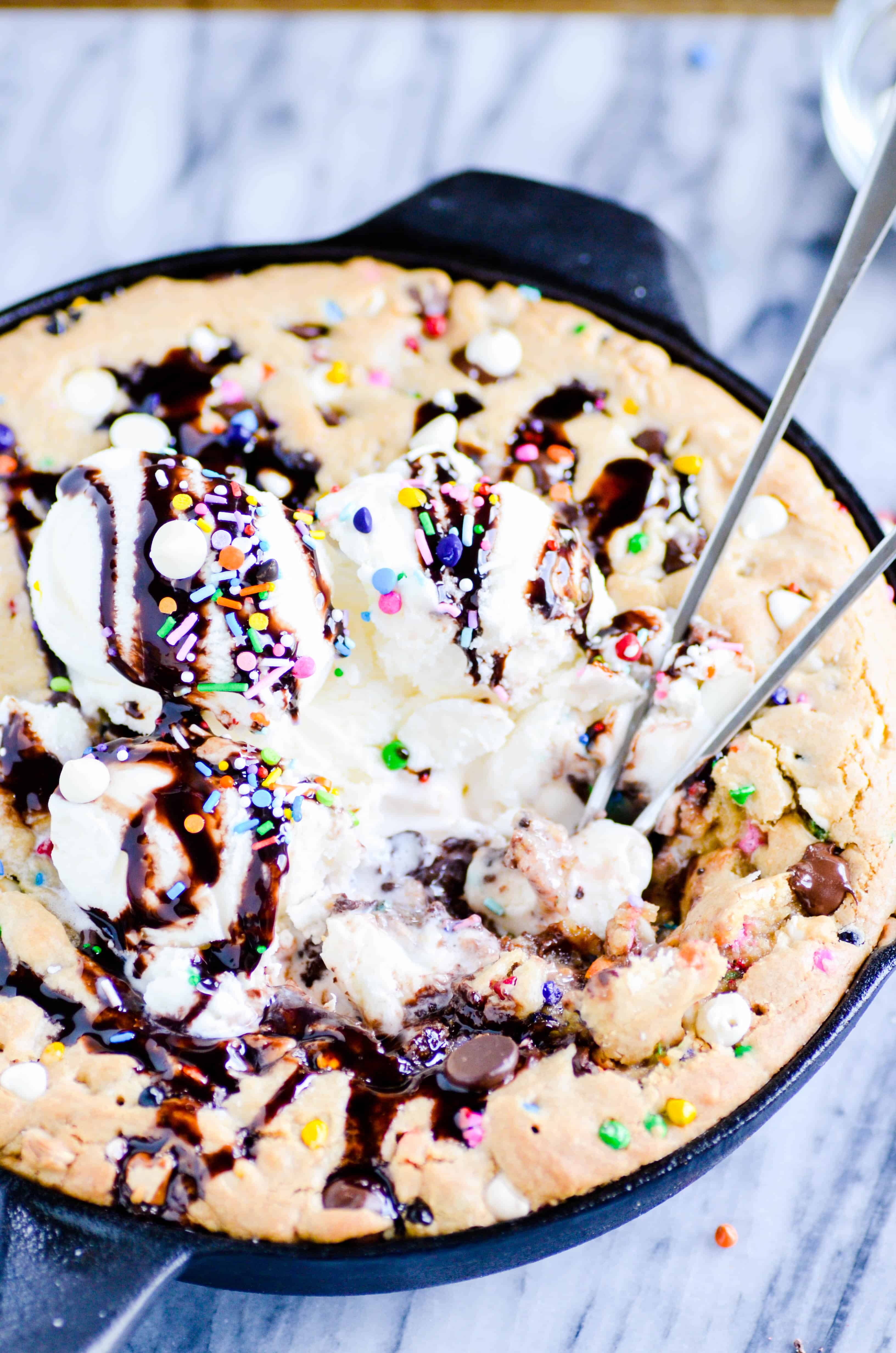 The most perfect dessert of all time is a warm, gooey, gigantic chocolate chip cookie filled with rainbow chips and topped with ice cream. How can it possibly get better than this?!