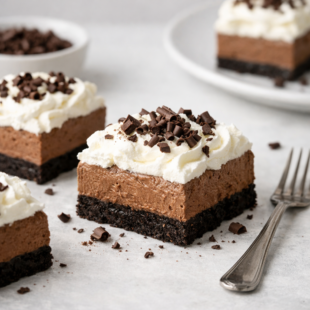 These french silk pie bars have a dreamy chocolate filling, graham cracker crust, and fluffy whipped cream on top. You have to make this! 🍫