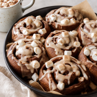 These hot cocoa cinnamon rolls are gooey, chocolatey, and topped with dreamy marshmallow frosting. Your new favorite cozy winter breakfast! 🍫