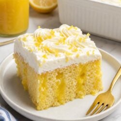 This Lemon Curd Poke Cake is moist, dreamy, and bursting with tart lemon flavor. So easy and absolutely delicious — you have to make this! 🍋