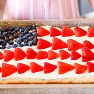 American flag fruit pizza with strawberries and blueberries on a sugar cookie crust