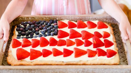 American flag fruit pizza with strawberries and blueberries on a sugar cookie crust