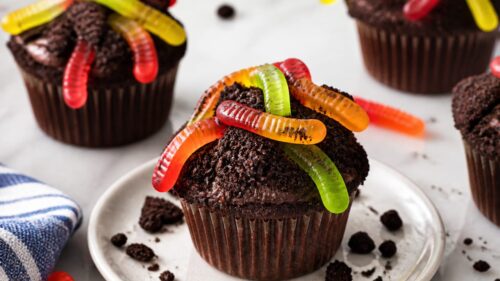 Dirt Cupcakes are the most fun spring dessert EVER — chocolate cupcakes dipped in Oreo crumbs with a candy strawberry carrot on top! 🌱
