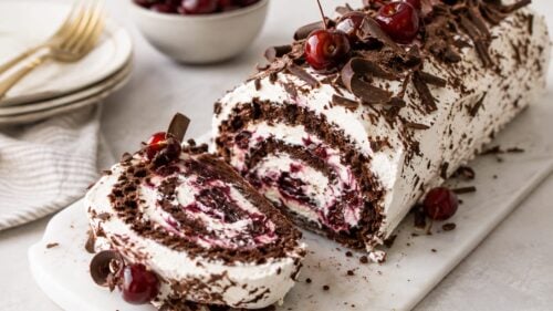 This dreamy Black Forest Ice Cream Cake Roll layers chocolate sponge, vanilla ice cream & cherries, all wrapped in glossy chocolate ganache!