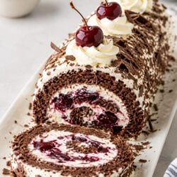 This dreamy Black Forest Ice Cream Cake Roll layers chocolate sponge, vanilla ice cream & cherries, all wrapped in glossy chocolate ganache!