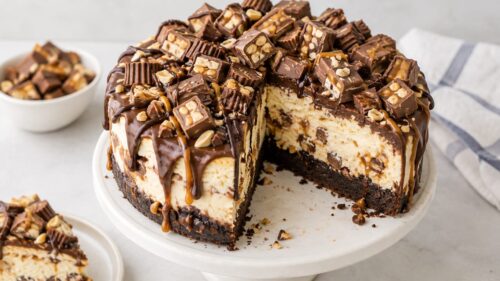 This candy bar cheesecake cake stacks chocolate cake, cheesecake, caramel & candy bars into one ah-mazing, over-the-top dessert!